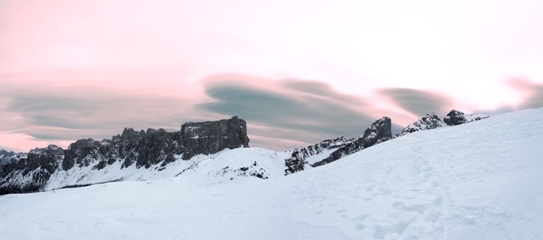 Breathtaking winter mountain scenery with snow and a vibrant pink sunset sky.