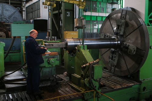 A Man Checking Machinery at an Industrial Plant