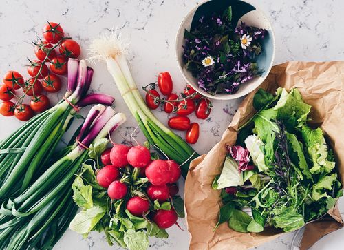 Free Vibrant flat lay of fresh vegetables and greens on a marble surface. Perfect for food blogs. Stock Photo