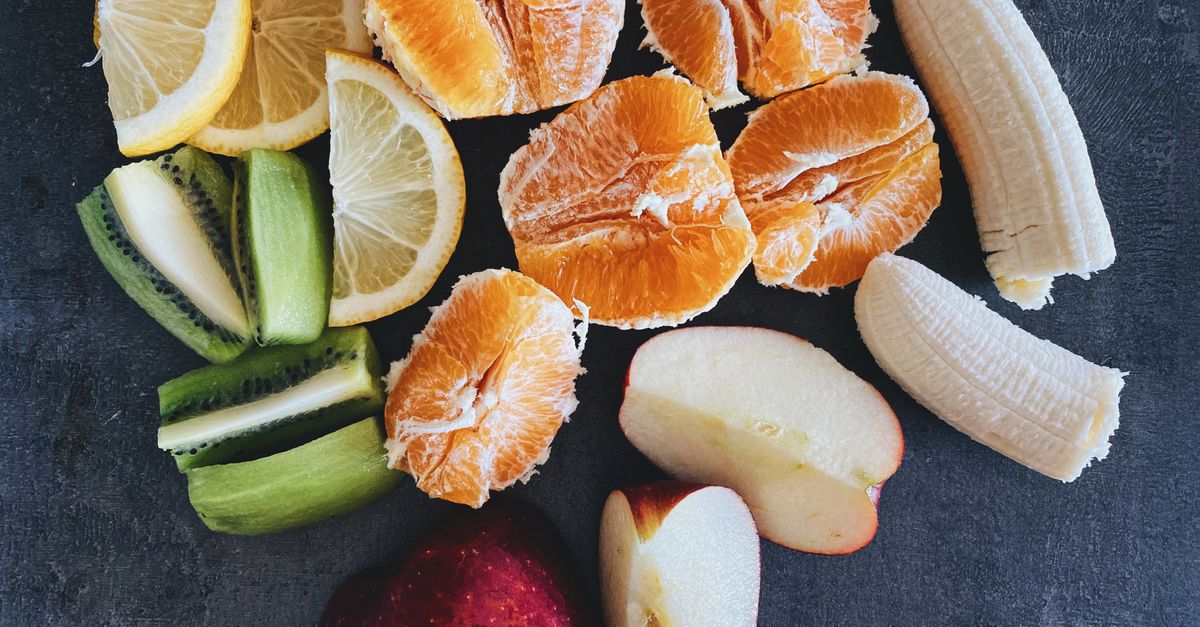 An arrangement of fresh fruits including oranges, apples, bananas, and lemons on a dark background. - Evidence evidence guide for vitamin B6 PMS meta-analysis