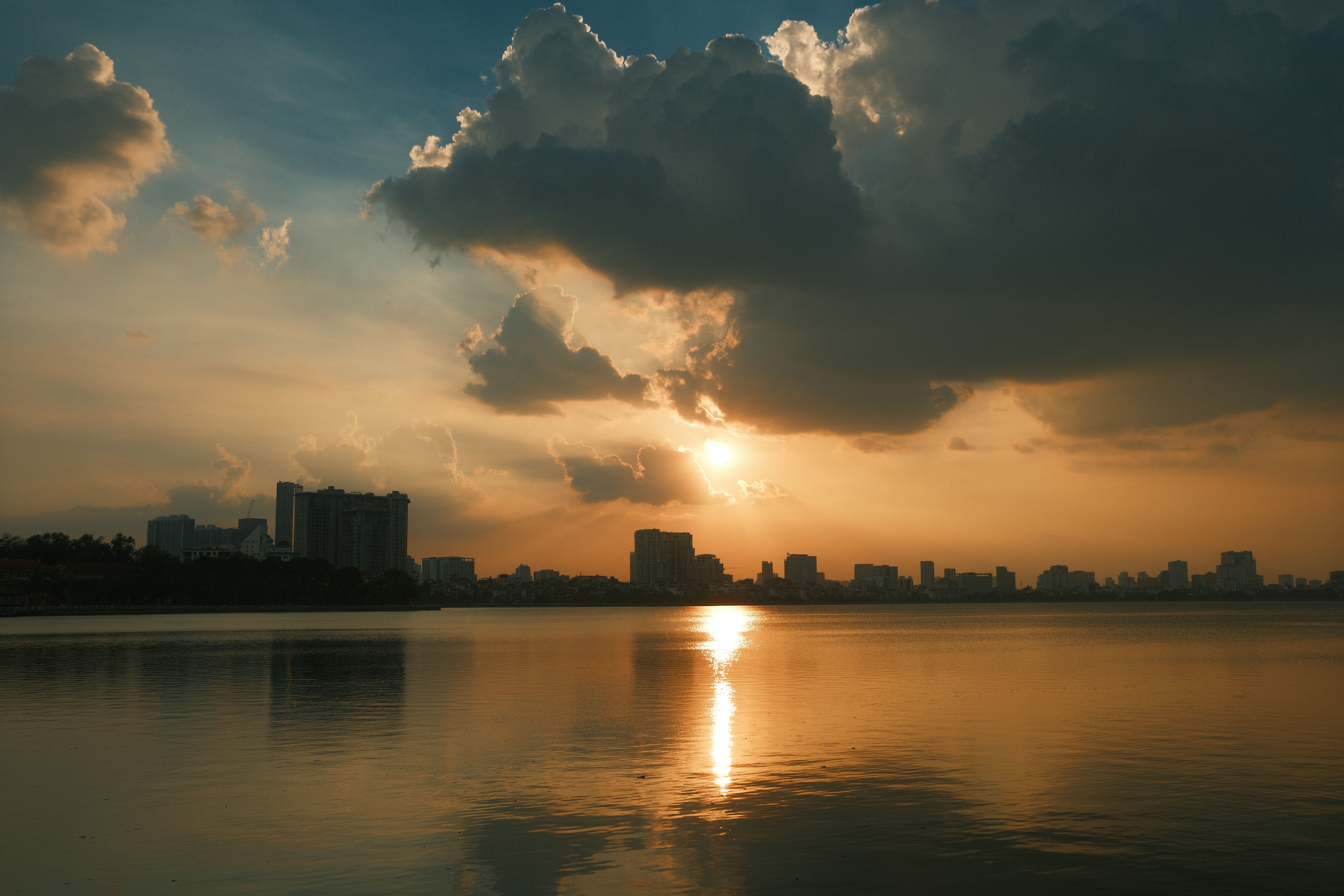 City Skyline at Sunset Reflecting on Calm Water · Free Stock Photo