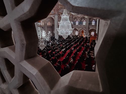 Free A captivating view inside a mosque, showcasing a large congregation and stunning interior chandelier. Stock Photo