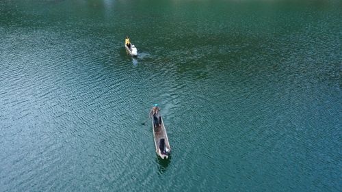 Free Aerial view of two canoes with people paddling on a calm lake. Stock Photo