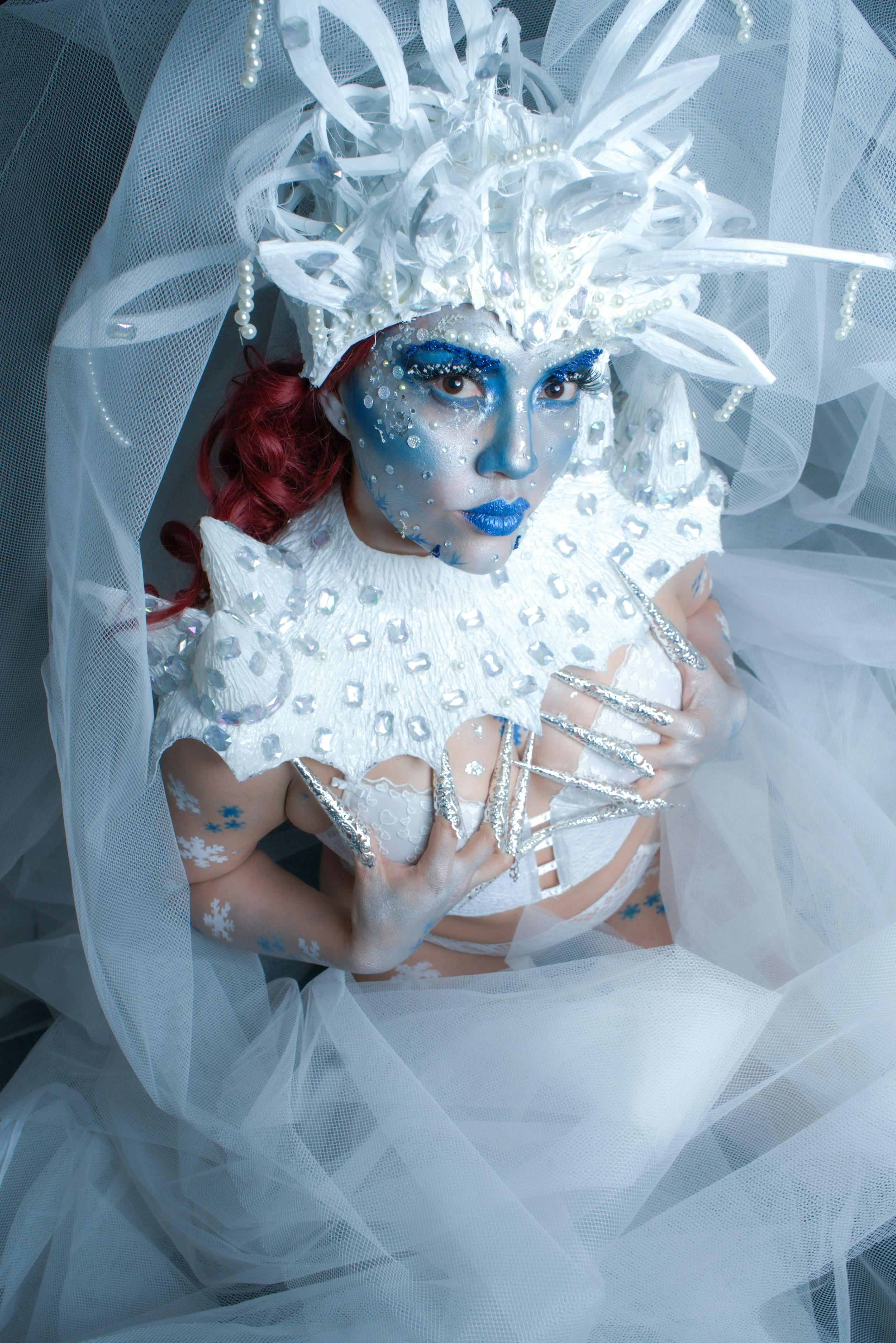 Kostenlos Dramatisches Porträt einer Fantasy-Eiskönigin mit blauem Make-up und aufwendigem weißen Kostüm. Stock-Foto