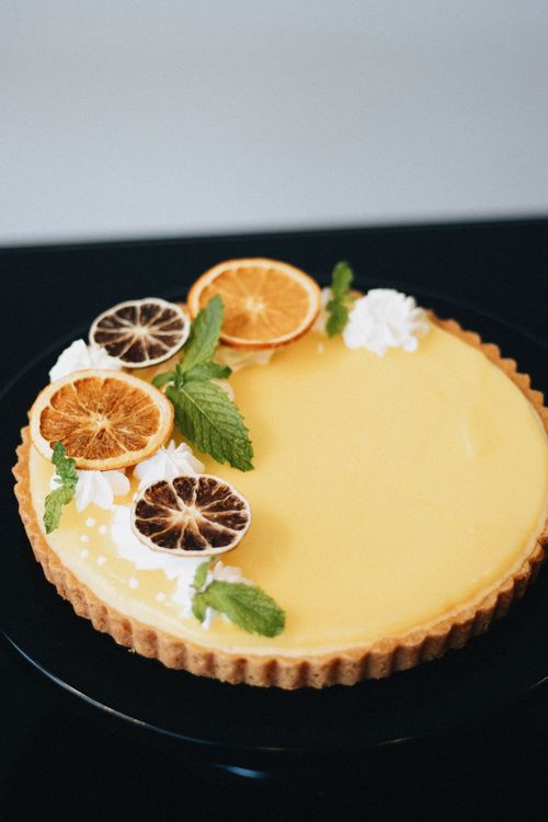 Free Elegant citrus tart with dried orange garnish and fresh mint for gourmet appeal. Stock Photo