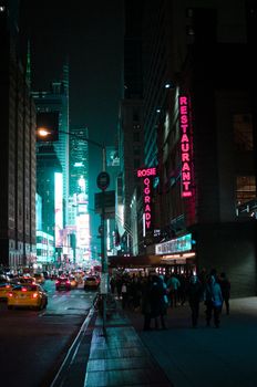 A bustling New York City street scene at night with glowing signs and lively atmosphere.