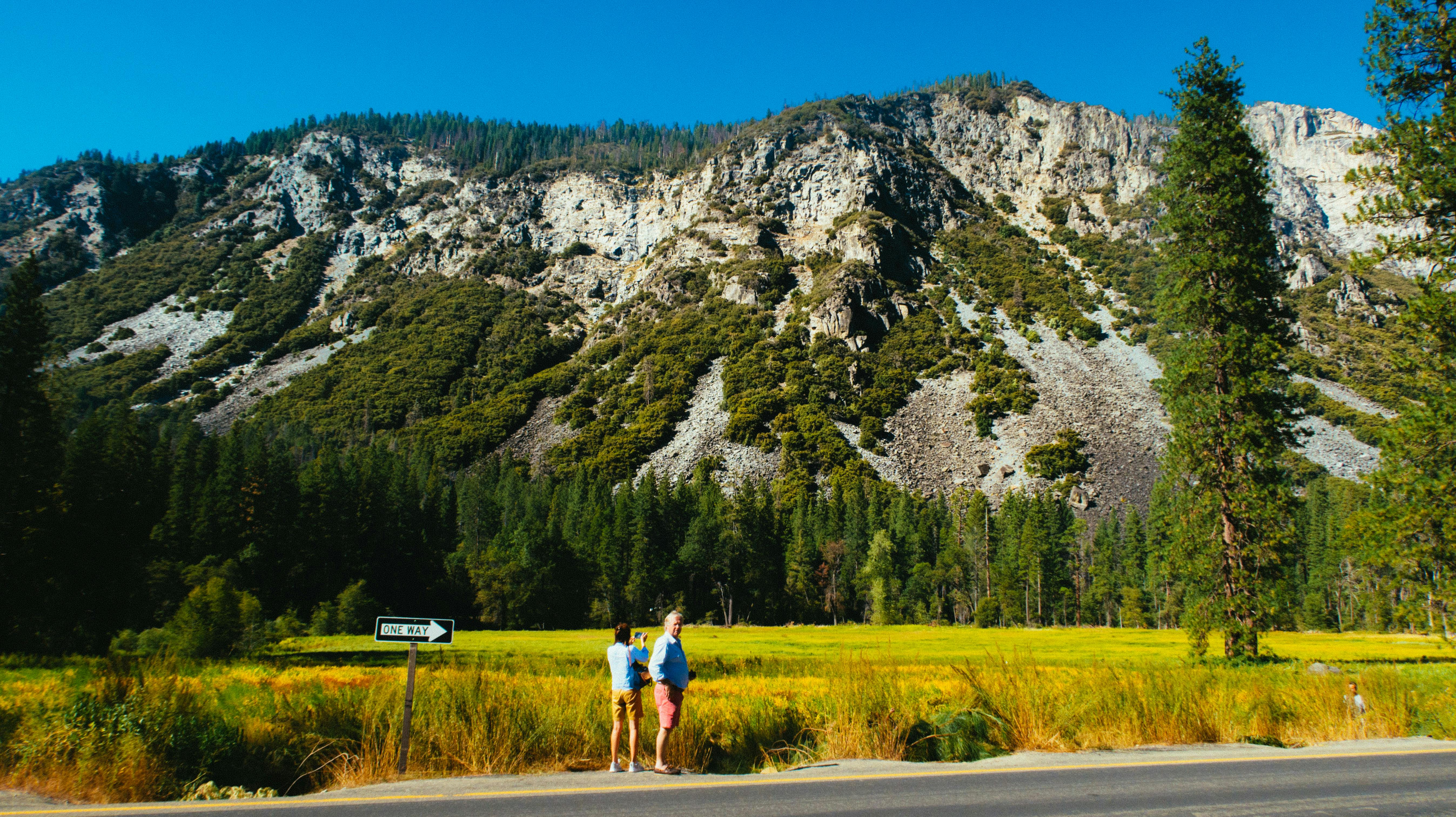 在一个阳光明媚的夏日，两名徒步旅行者探索了风景优美的山地景观