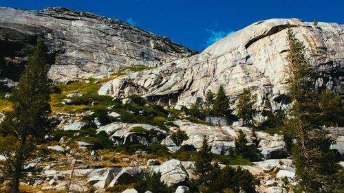 Free A breathtaking view of rocky mountain peaks under a clear blue sky and lush greenery. Stock Photo