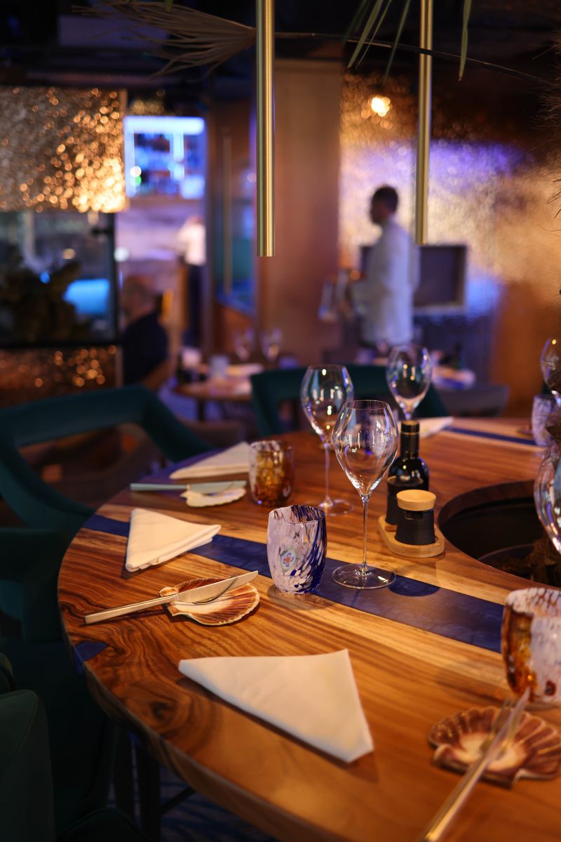 Warmly lit Ember & Salt dining room set for dinner