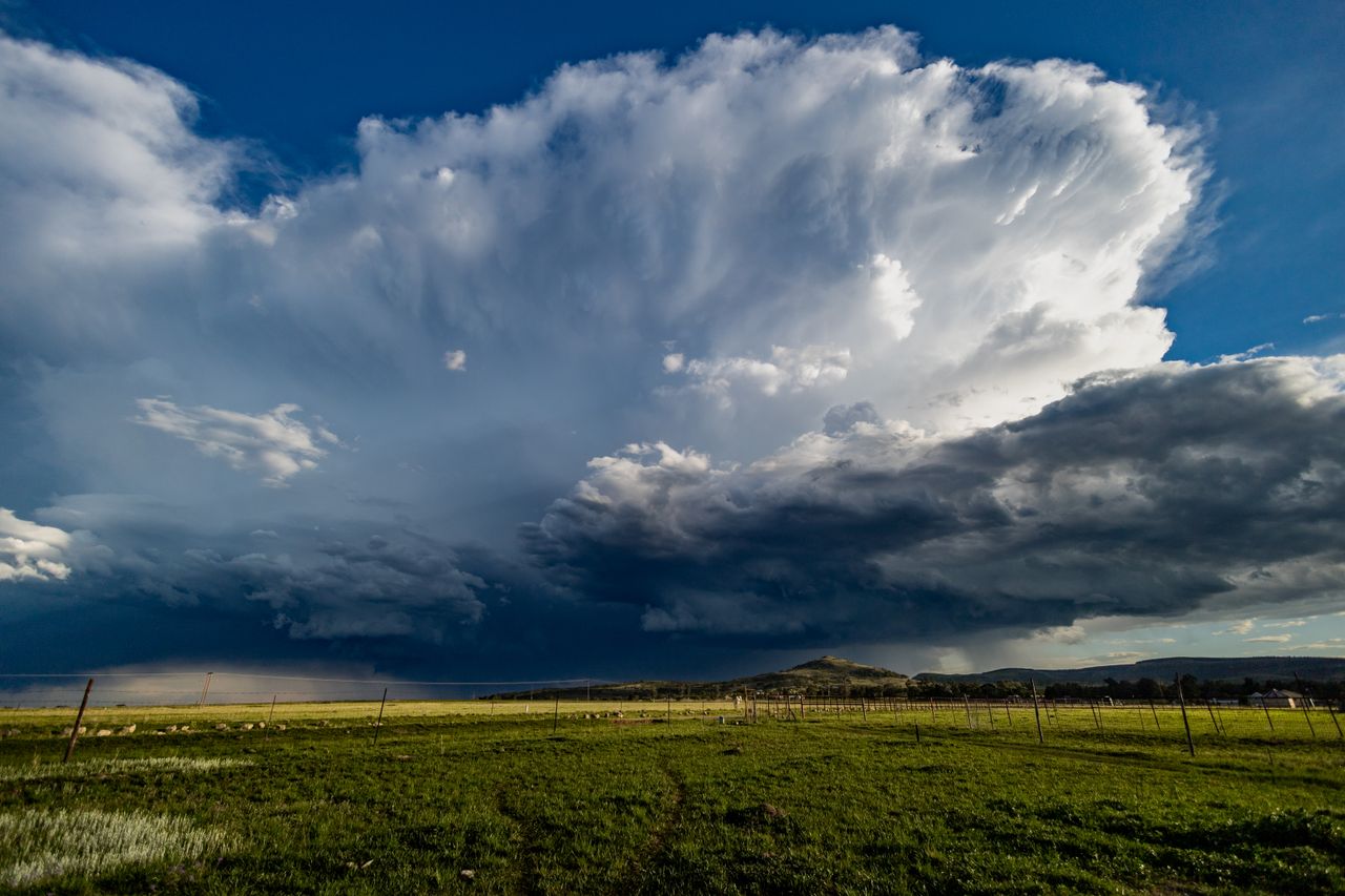 vast cumulonimbus cloud rises over grassy field in kwazulu natal south