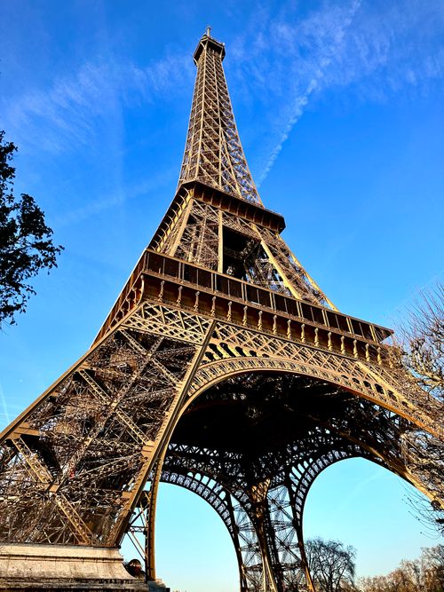 Free Upward view of the iconic Eiffel Tower on a sunny Paris day. Stock Photo