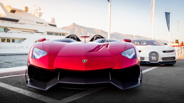 Elegant hypercar showcased at a scenic marina in Marbella, Spain.