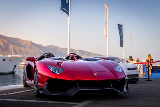 Stunning red supercar parked by Marbella marina during sunset, exuding elegance and power.