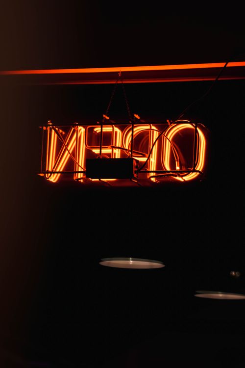 Free Vibrant neon 'OPEN' sign illuminating a dim restaurant atmosphere, adding a modern touch. Stock Photo