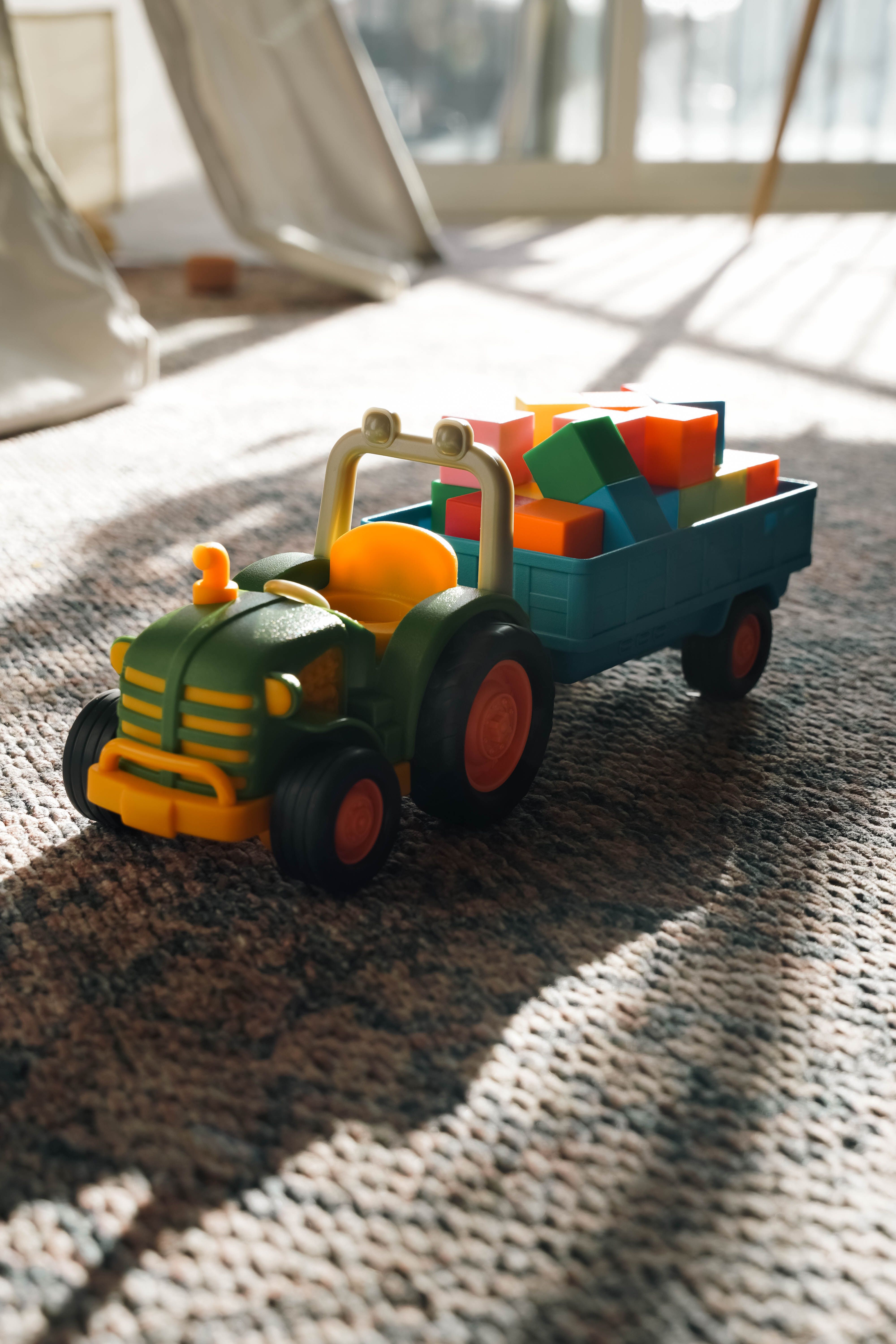 Colorful Toy Tractor on Carpet in Sunlit Room · Free Stock Photo