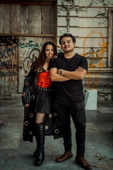 A fashionable couple poses together in an urban setting in Puebla, Mexico, expressing modern romance.
