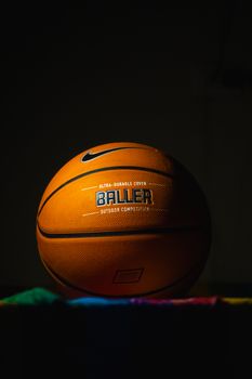 A striking basketball in focus with bold branding against a dark backdrop, capturing sports essence.