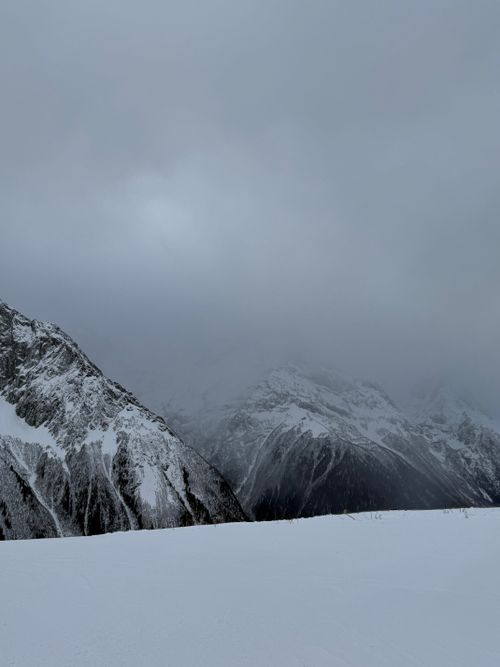 Free Moody winter mountains shrouded in clouds against a snowy backdrop. Stock Photo