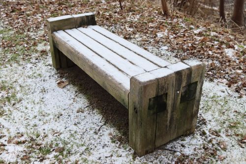 Free A wooden bench dusted with snow in a tranquil winter forest setting. Stock Photo