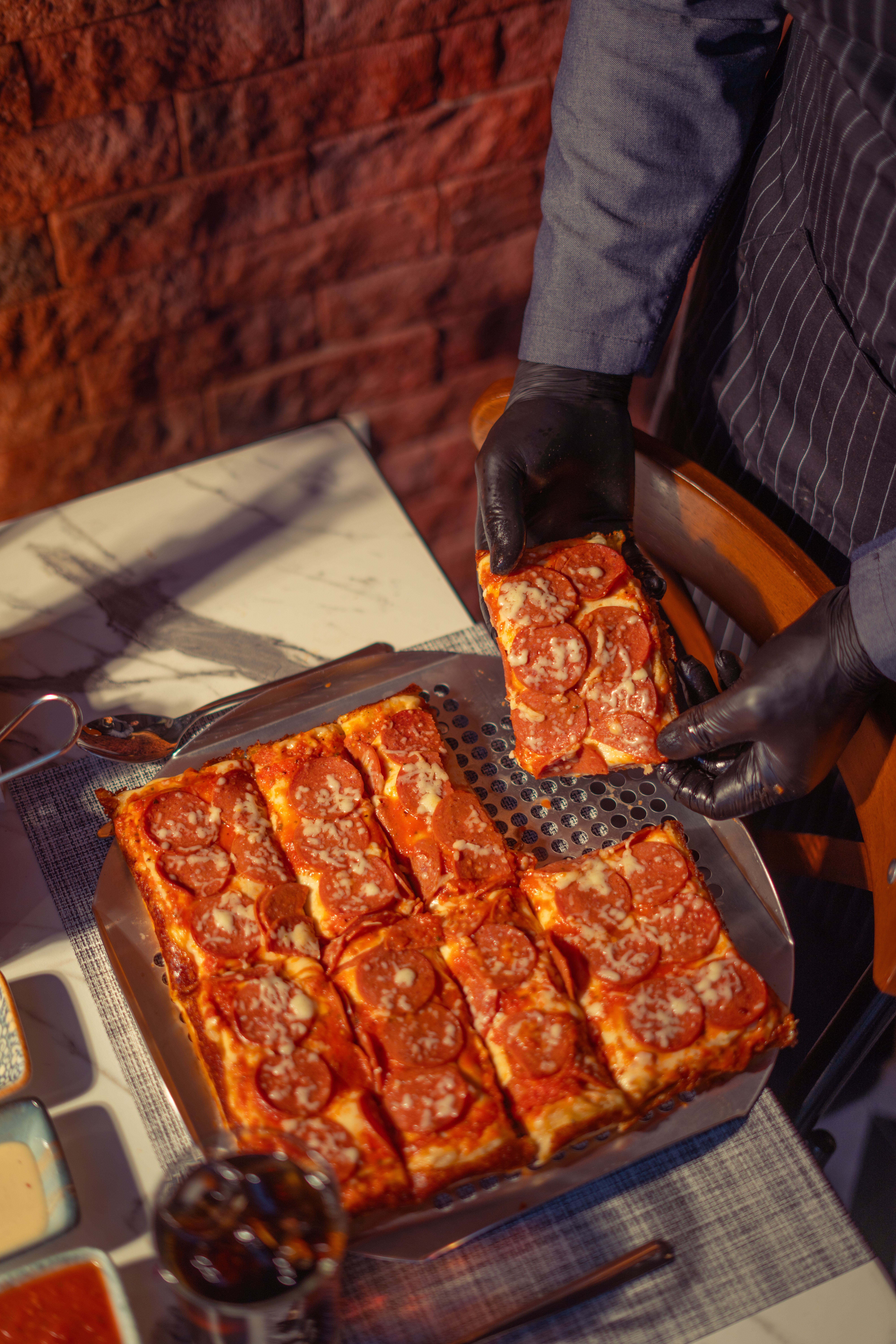 Fresh square-cut pizza slices arranged on a metal