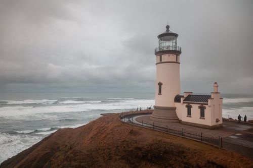Free Scenic view of Cape Disappointment Lighthouse overlooking the Pacific Ocean on a cloudy day. Stock Photo