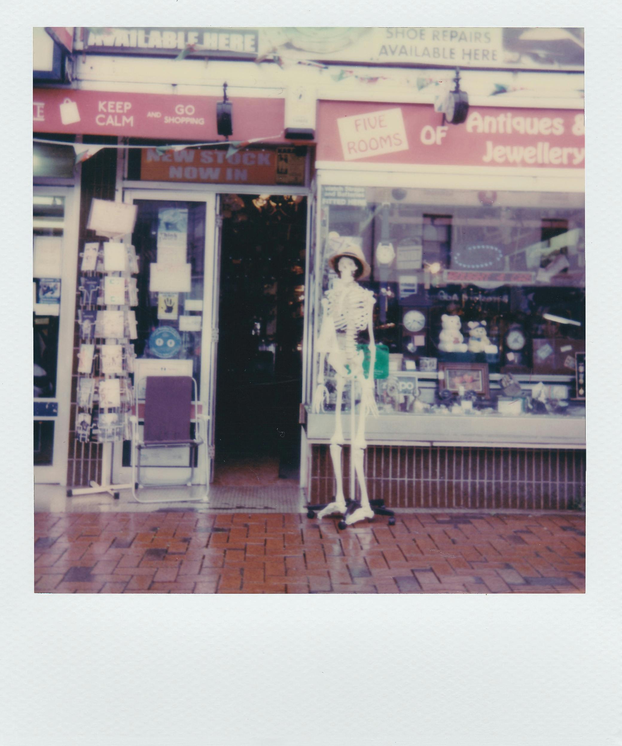 A vintage-style photo of an antique and jewelry shop with a skeleton mannequin.