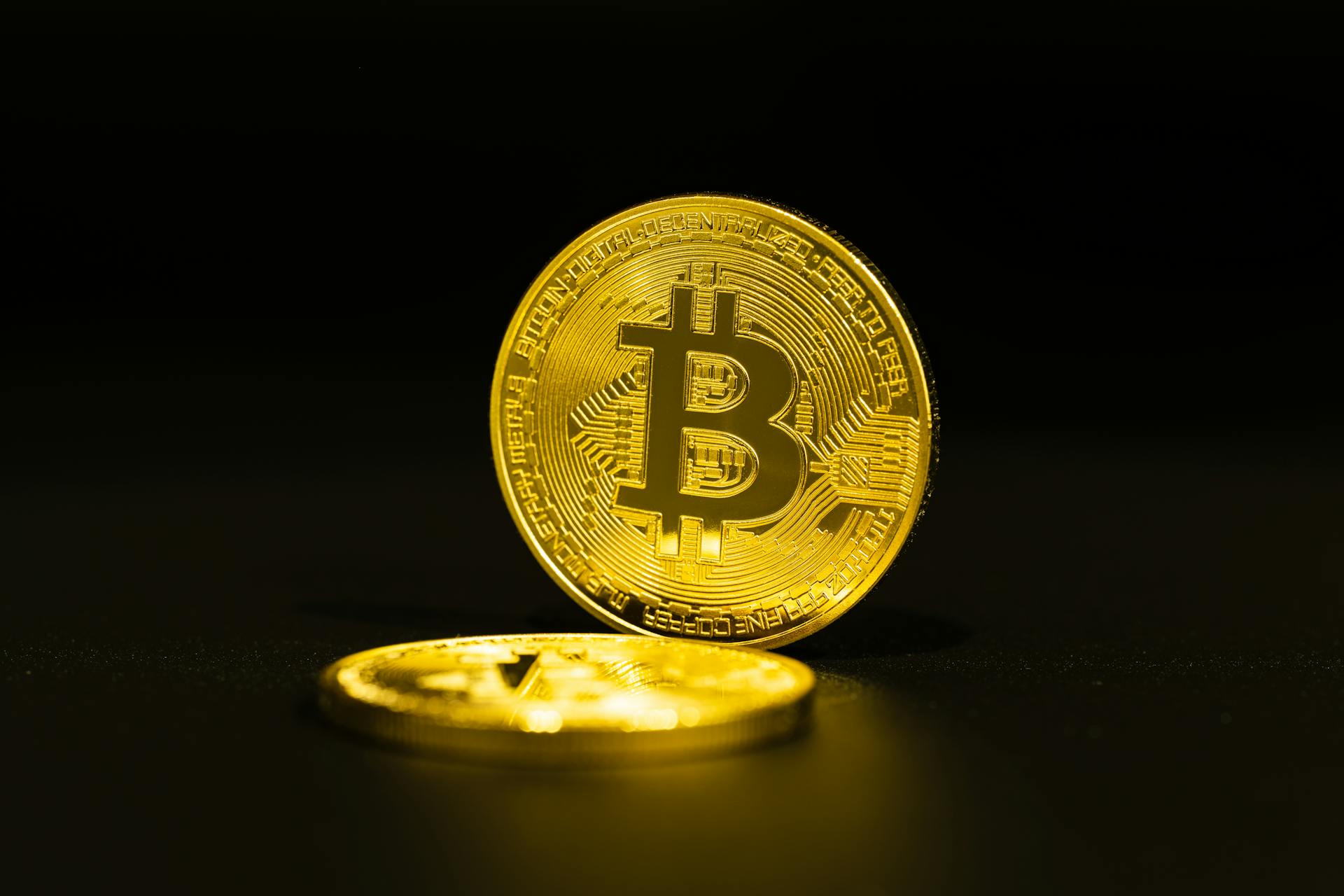 Close-up of gold Bitcoin coins on a dark background, symbolizing cryptocurrency.