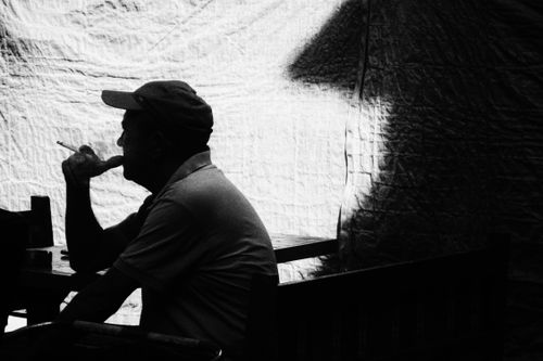 Free Moody black and white photo of a man smoking in silhouette, creating a dramatic atmosphere. Stock Photo