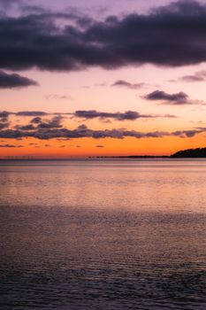 Captivating sunset view over Lake Ontario with vivid colors and dramatic clouds in Toronto, Canada.