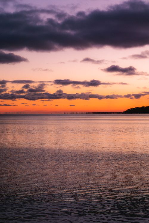 Free Captivating sunset view over Lake Ontario with vivid colors and dramatic clouds in Toronto, Canada. Stock Photo