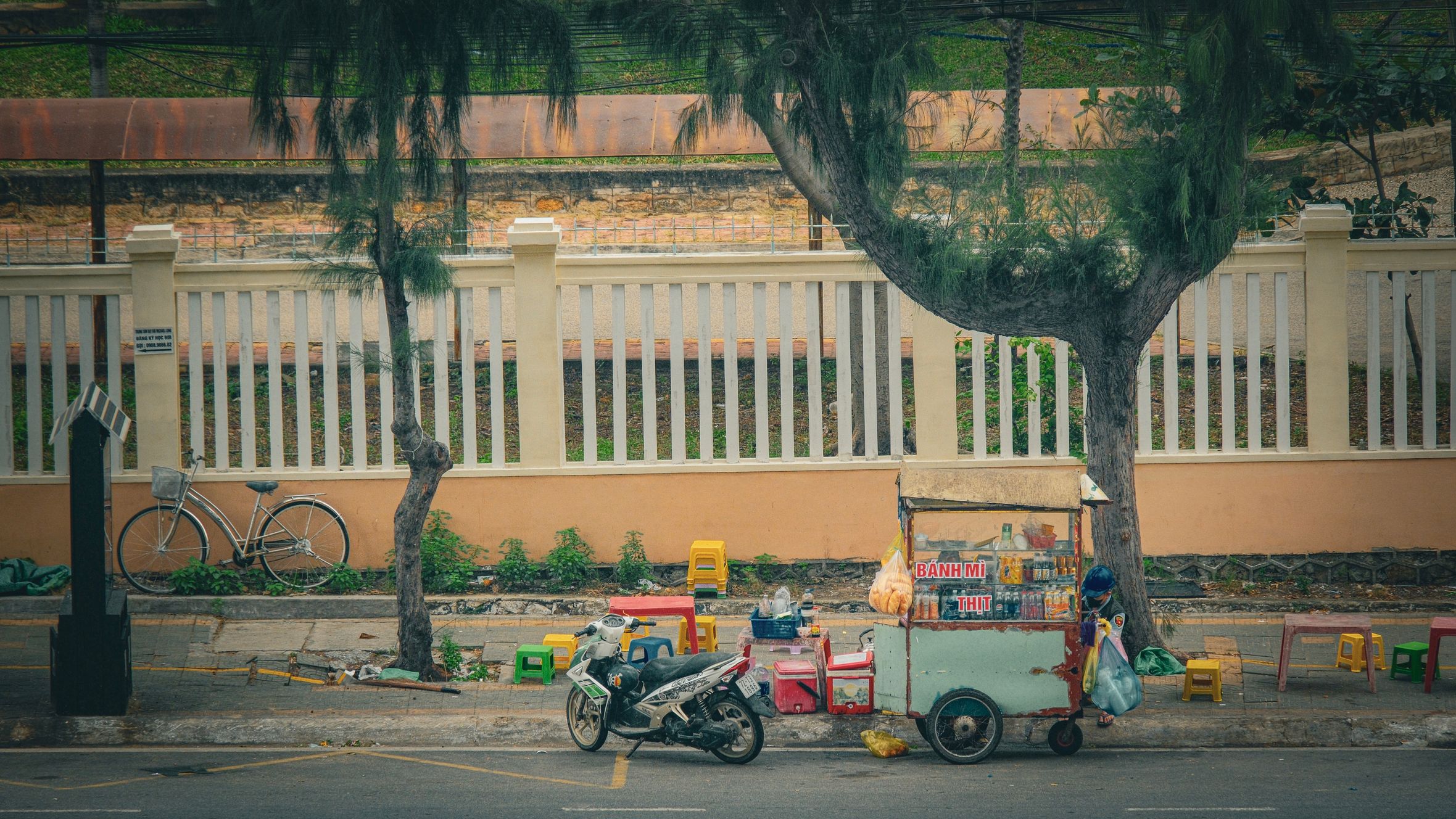 Traditional Vietnamese street food cart in Vũng Tàu cityscape setting.