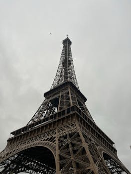 Majestic view of the Eiffel Tower rising against a cloudy sky in Paris, France.