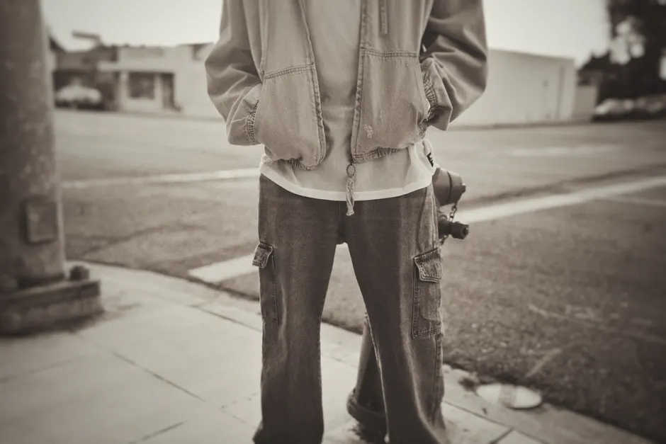 Silhouette urbaine en jean cargo large et veste oversize vue de dos dans la rue