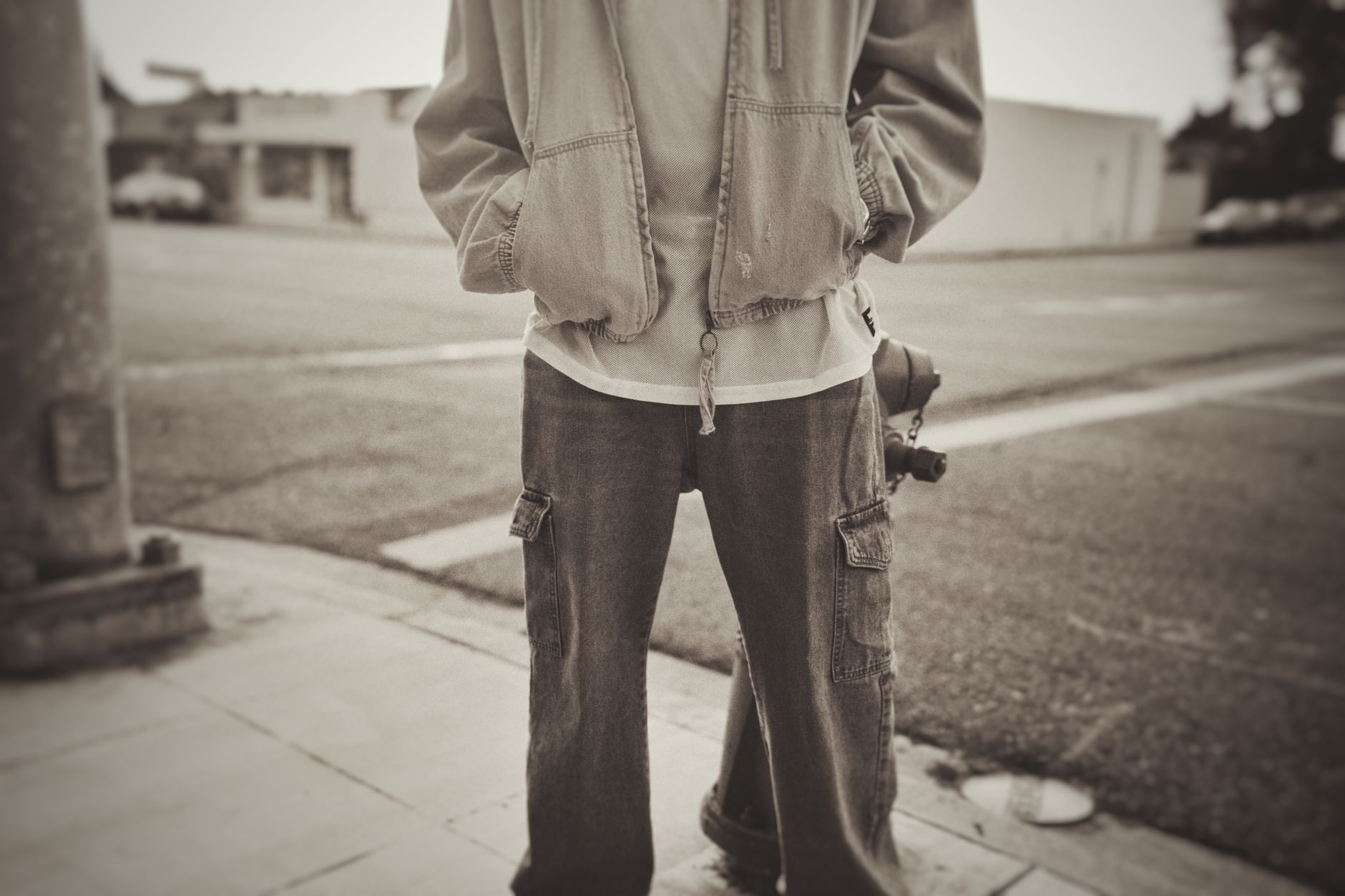Silhouette urbaine en jean cargo large et veste oversize vue de dos dans la rue