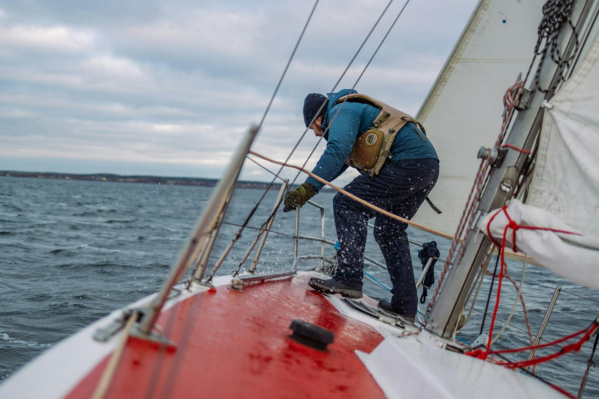 A sailor maneuvers on a yacht during a brisk day on the waters of Belarus.