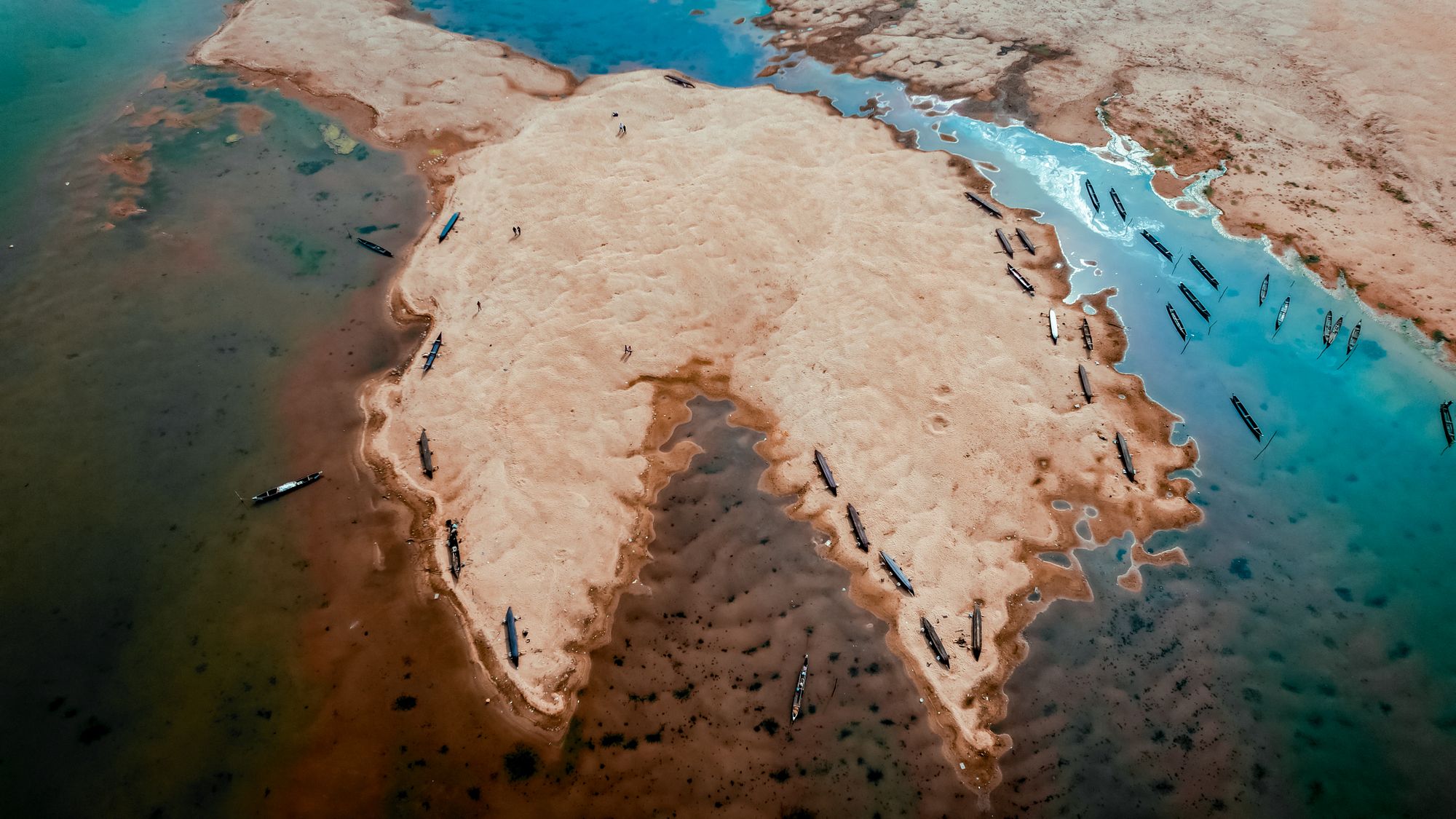 Vista aérea de un delta fluvial ramificado que se abre en abanico al llegar al mar