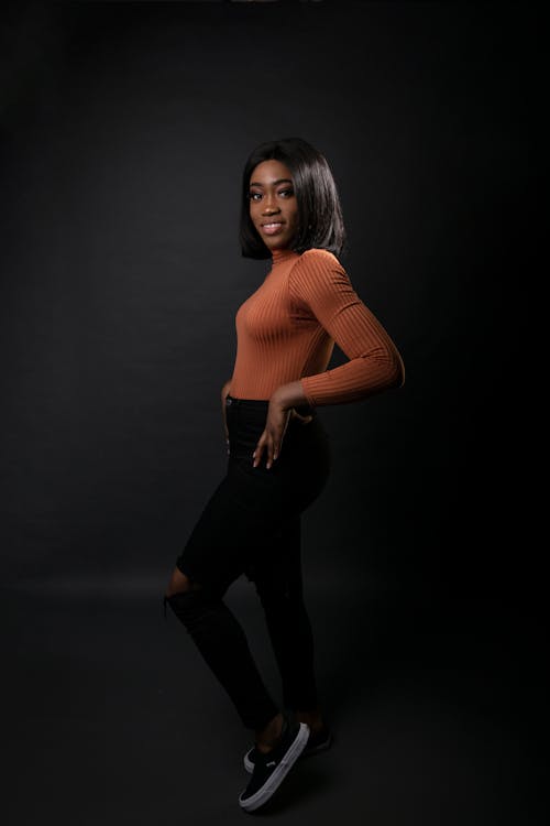 Free Woman Wearing Orange Long-sleeved Shirt and Black Jeans Stock Photo