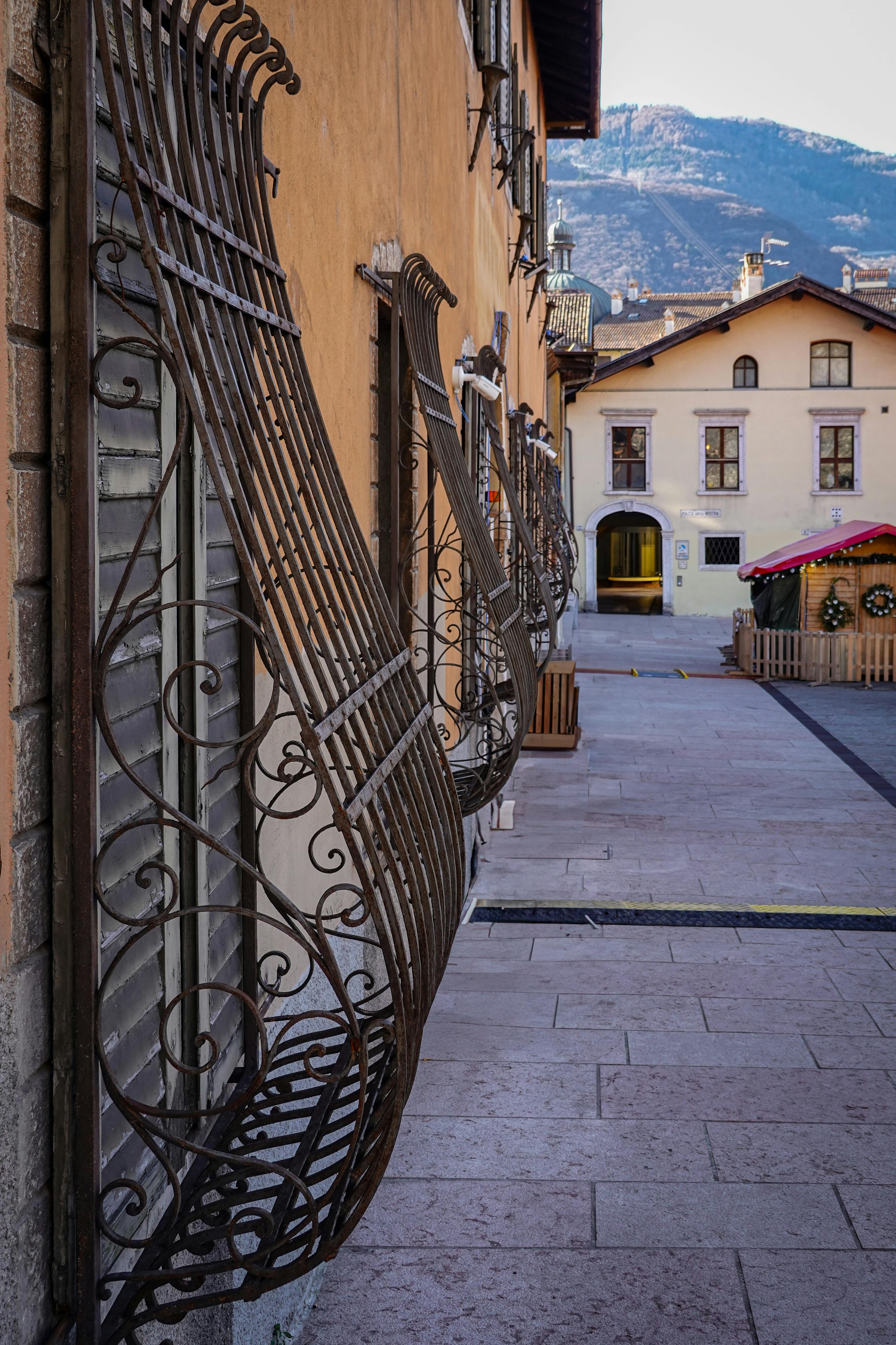 Charming Italian village alley with ornate railings · Free Stock Photo