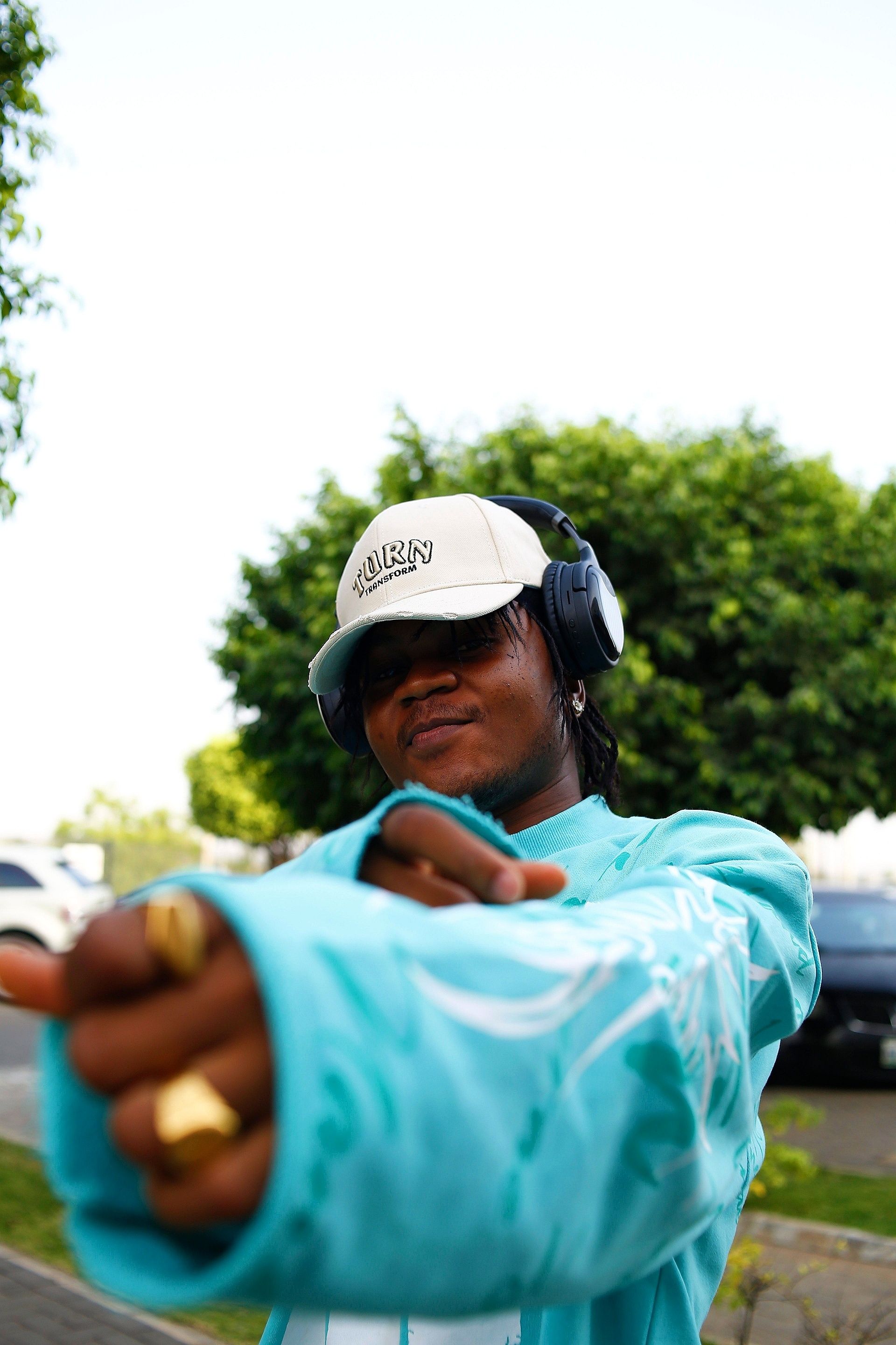 Portrait of a young adult with headphones and trendy outfit in Abuja, Nigeria.
