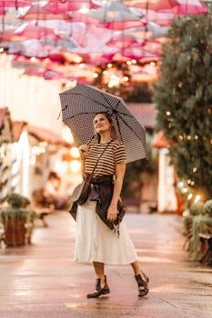 一位撑着伞的女人微笑着，漫步在灯火通明、装饰一新的街道上