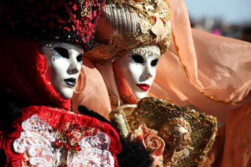 Free Elegant Venetian masks with elaborate costumes and intricate embroidery at a carnival event. Stock Photo