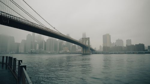 Free Moody view of Brooklyn Bridge with fog obscuring New York City's skyline. Stock Photo