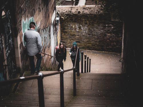 Free Moody urban scene with people on graffiti-lined stairs, conveying atmosphere and texture. Stock Photo