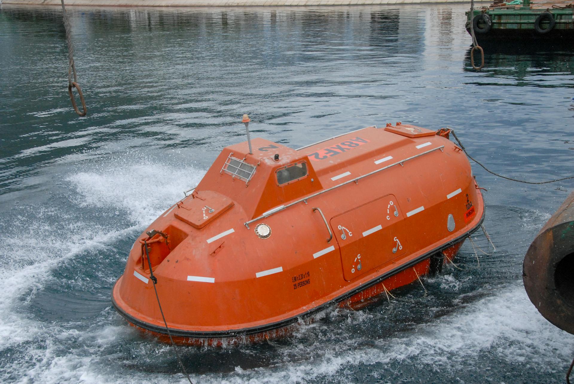 An orange lifeboat on water illustrating marine safety and rescue equipment.