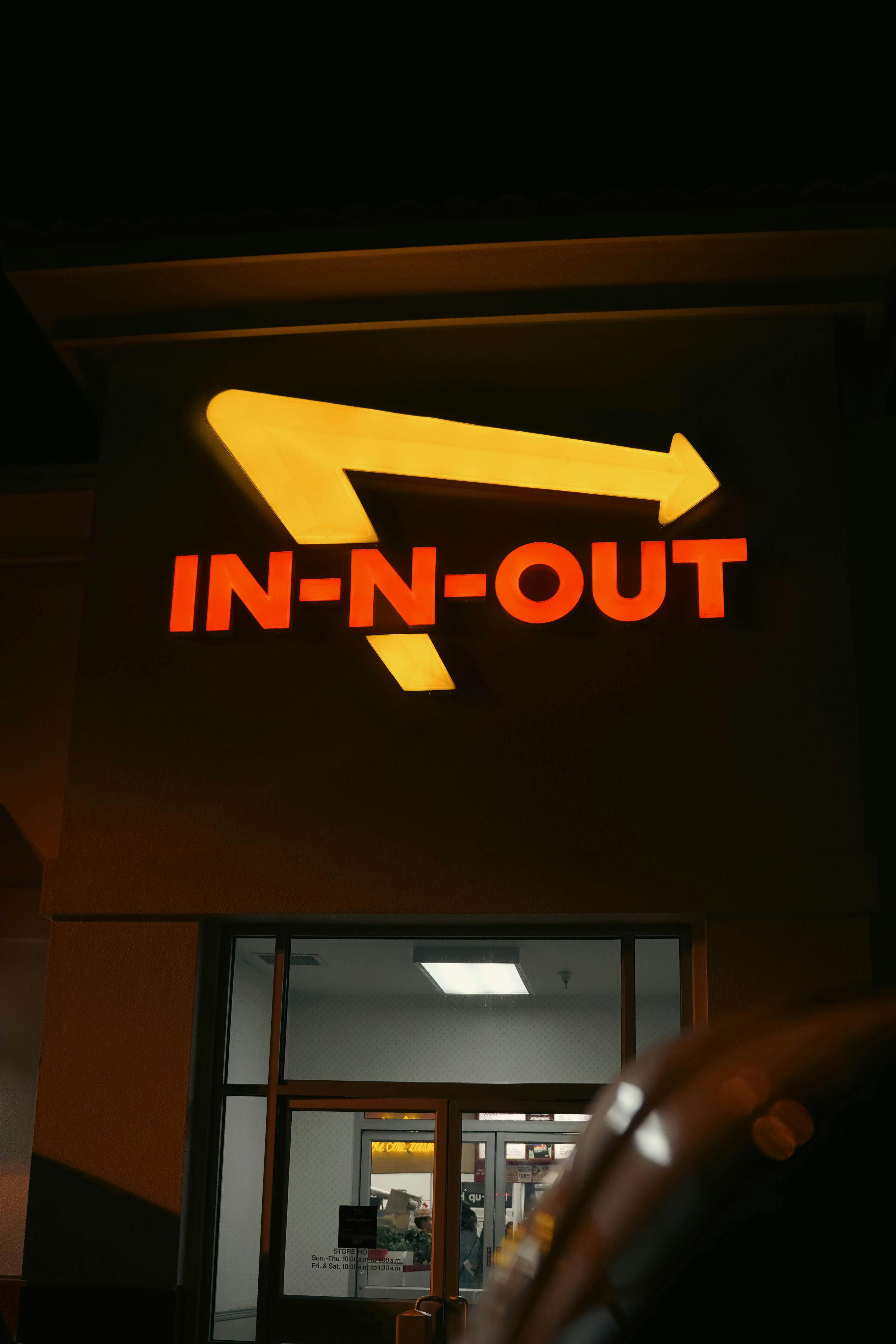 Night view of a famous fast-food chain In-N-Out illuminated sign. Bright and eye-catching.