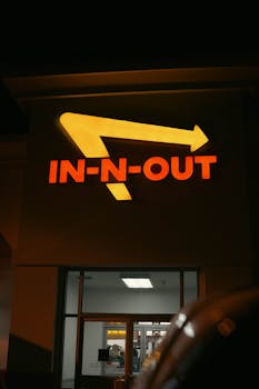 Night view of a famous fast-food chain In-N-Out illuminated sign. Bright and eye-catching.