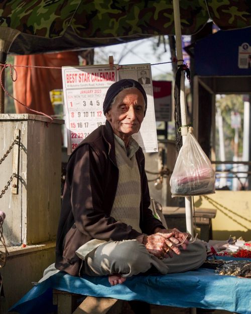 Free Elderly vendor sits peacefully on a Kolkata street, illustrating vibrant local life. Stock Photo