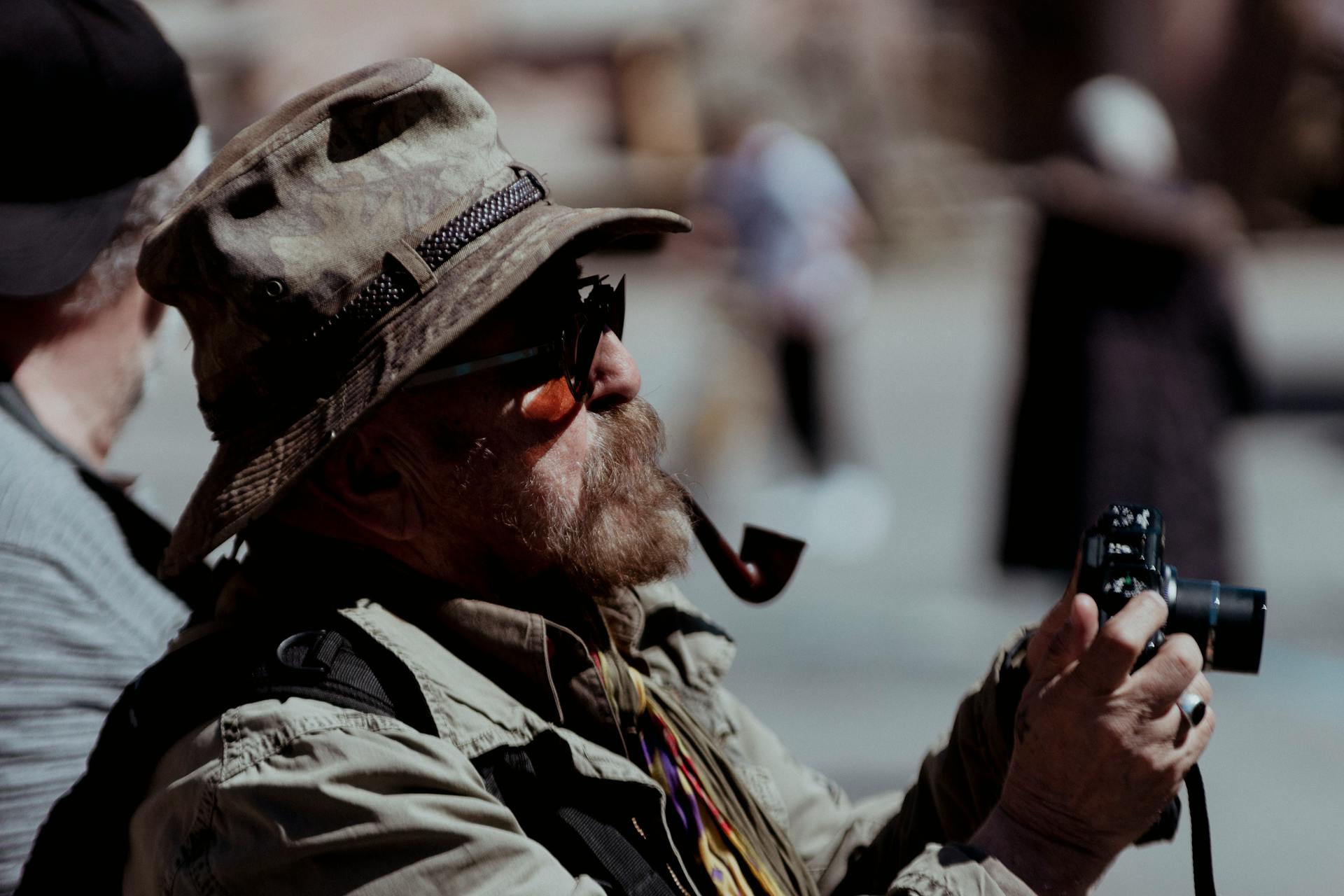 Senior man with a pipe and camera enjoying a day in İstanbul outdoors.