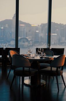 A stylish restaurant setting with a breathtaking city skyline view at twilight.