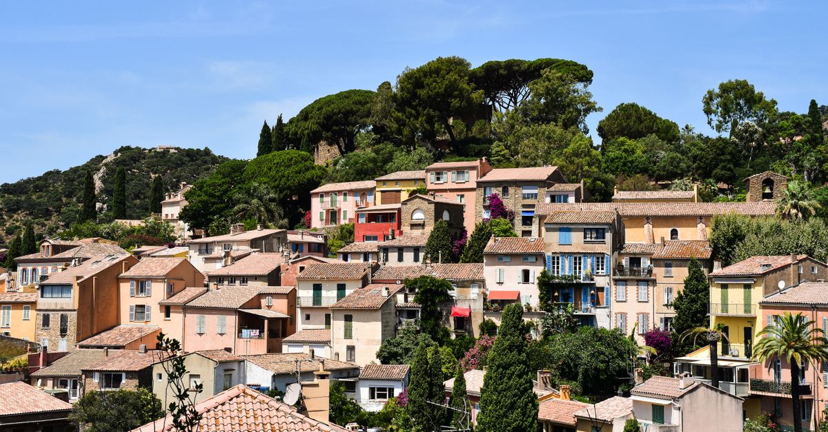 Picturesque view of colorful houses in Bormes-les-Mimosas, Provence, France under clear blue skies.